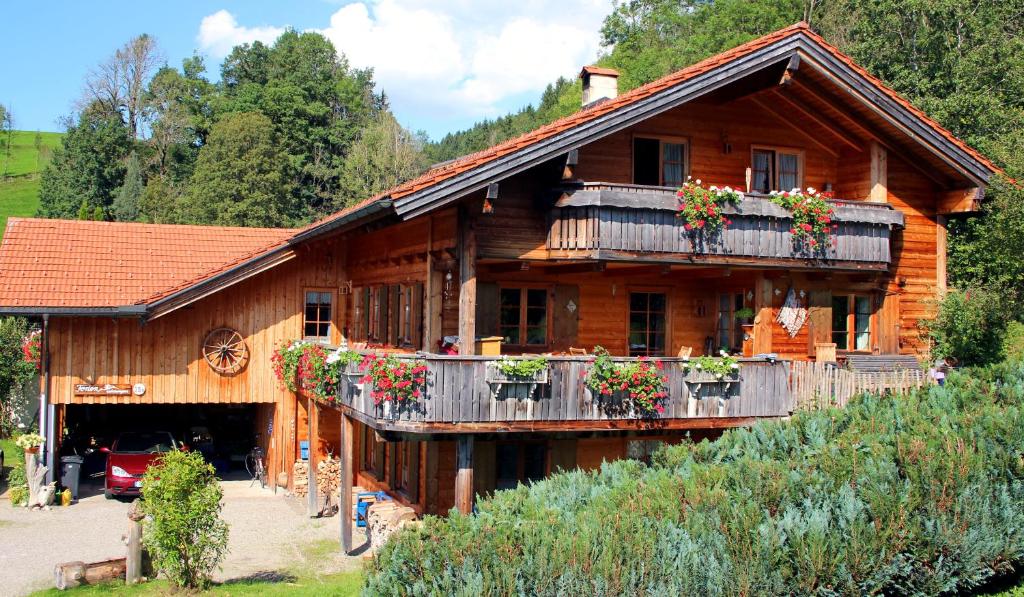 ein Holzhaus mit Blumenkästen auf dem Balkon in der Unterkunft Ferienwohnungen Bernie Schmid in Sonthofen