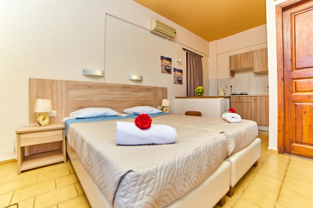 a bedroom with a bed with a red flower on it at Villa Diasselo in Malia