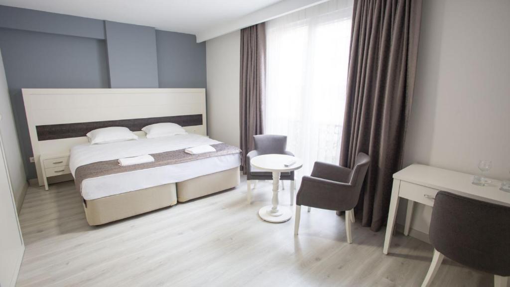 a bedroom with a bed and a table and a chair at Pruva Prestige Hotel in Ordu