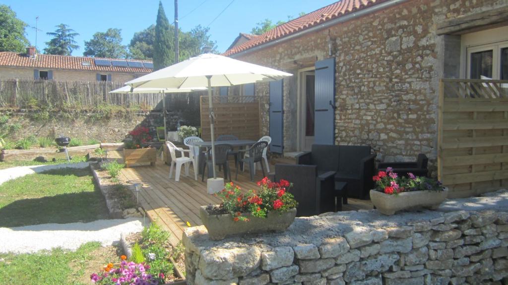 une terrasse avec un parasol, une table et des chaises dans l'établissement Aux delices de Saleix, à Sorges