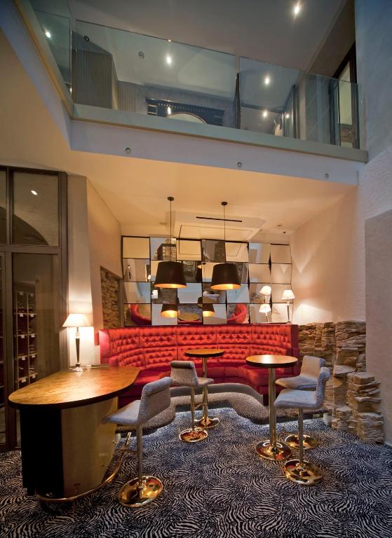 a lobby with a red couch and a table and chairs at Hotel Le Place d'Armes - Relais & Châteaux in Luxembourg