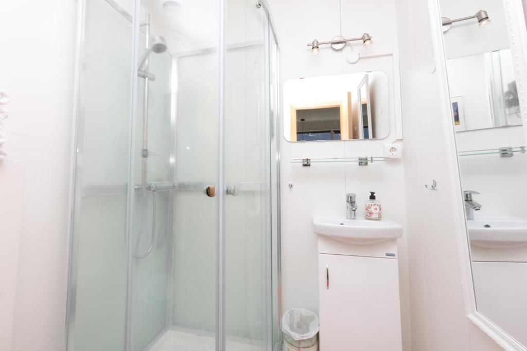 baño blanco con ducha y lavamanos en Blómasetrið Homestay, en Borgarnes