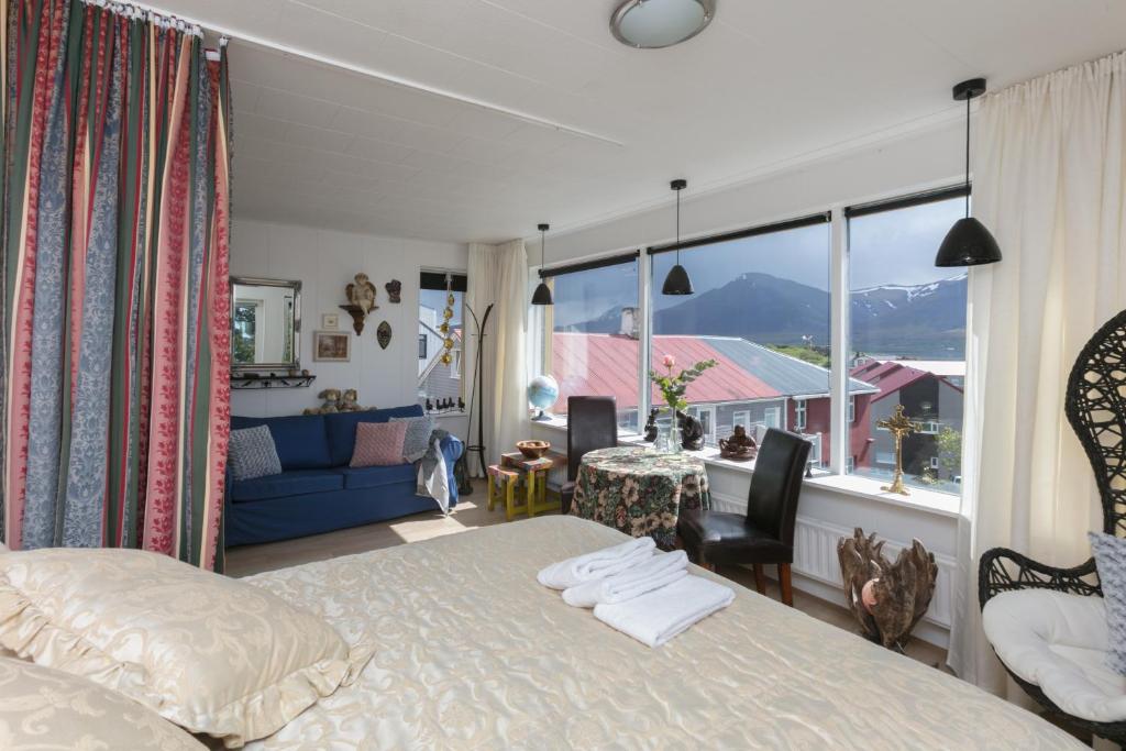 1 dormitorio con cama, mesa y ventana grande en Blómasetrið Homestay, en Borgarnes