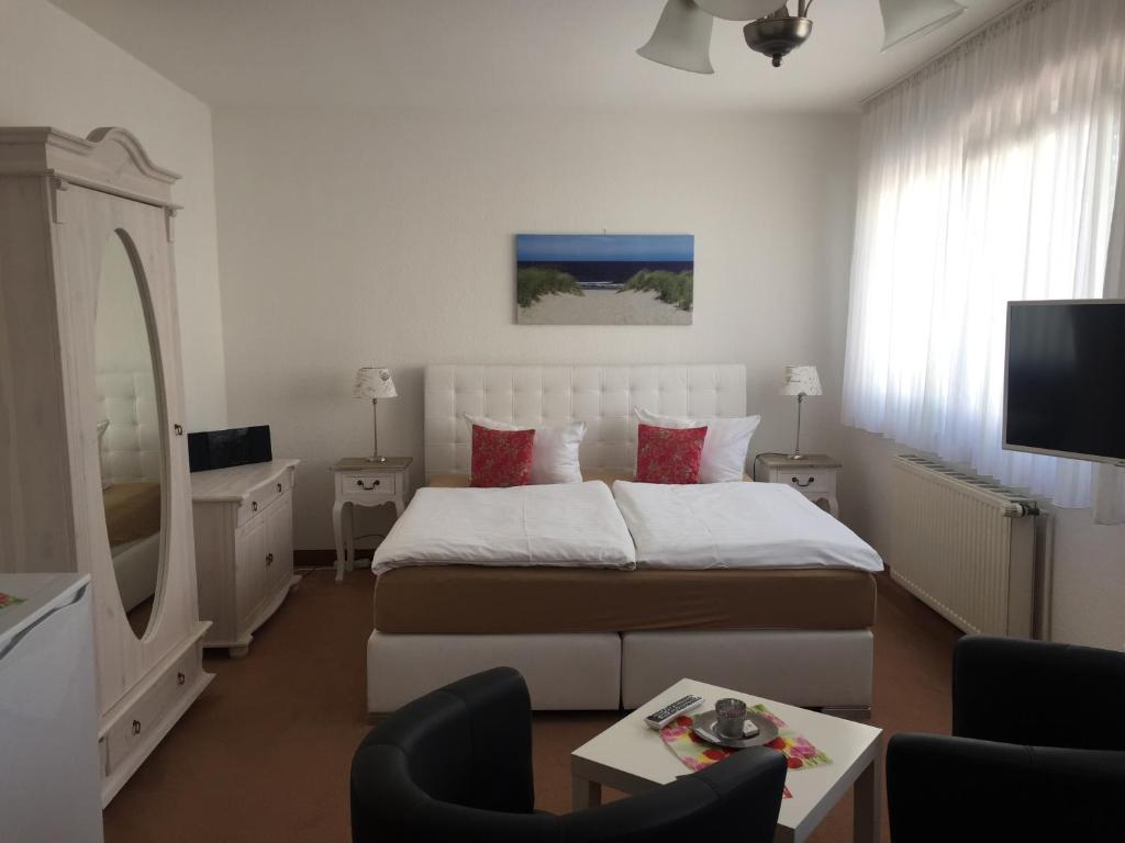 a bedroom with a large bed and a living room at Pension Marion in Binz