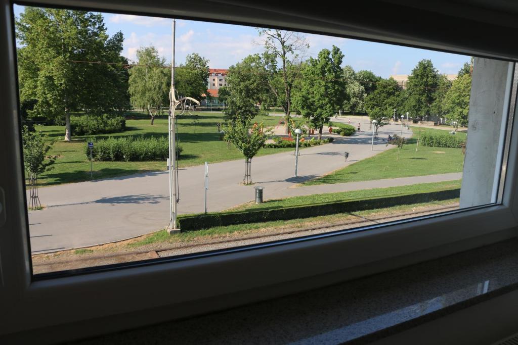 a view of a park from a window at Luma 2 in Osijek