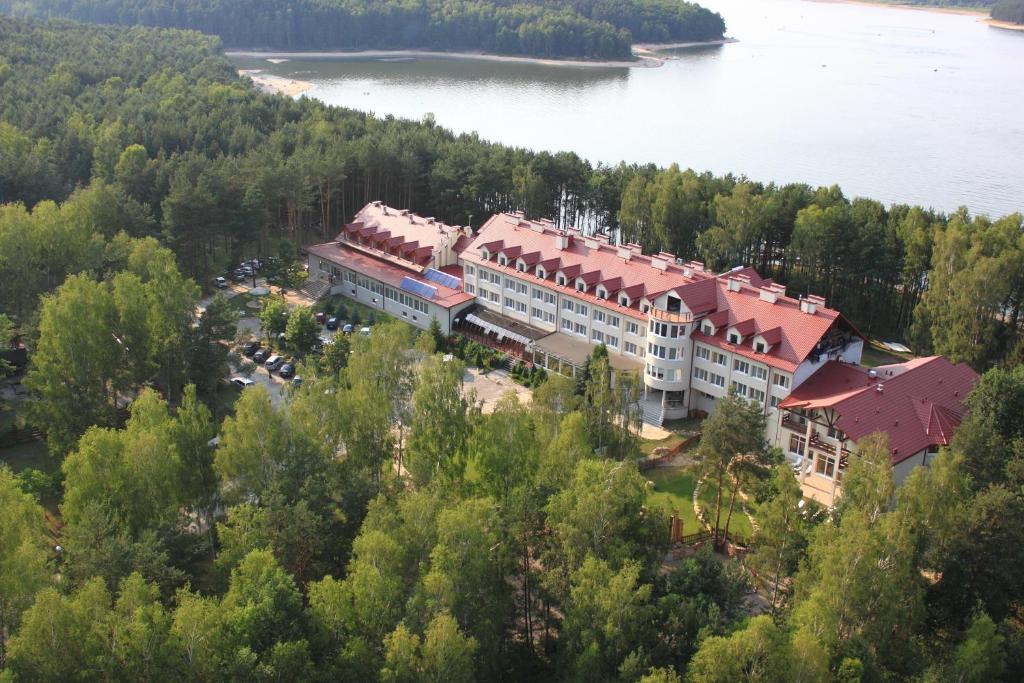 an aerial view of a building on a hill next to a lake at Cztery Wiatry Aparthotel in Korytnica
