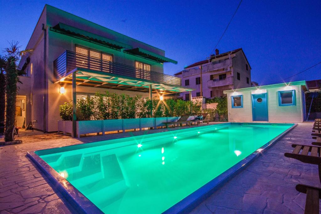 a swimming pool in front of a house at Apartments Gardelin Superior in Zadar