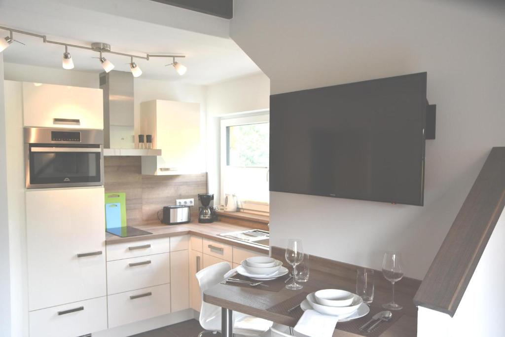 a kitchen with white cabinets and a table at Gästehaus Verl in Verl