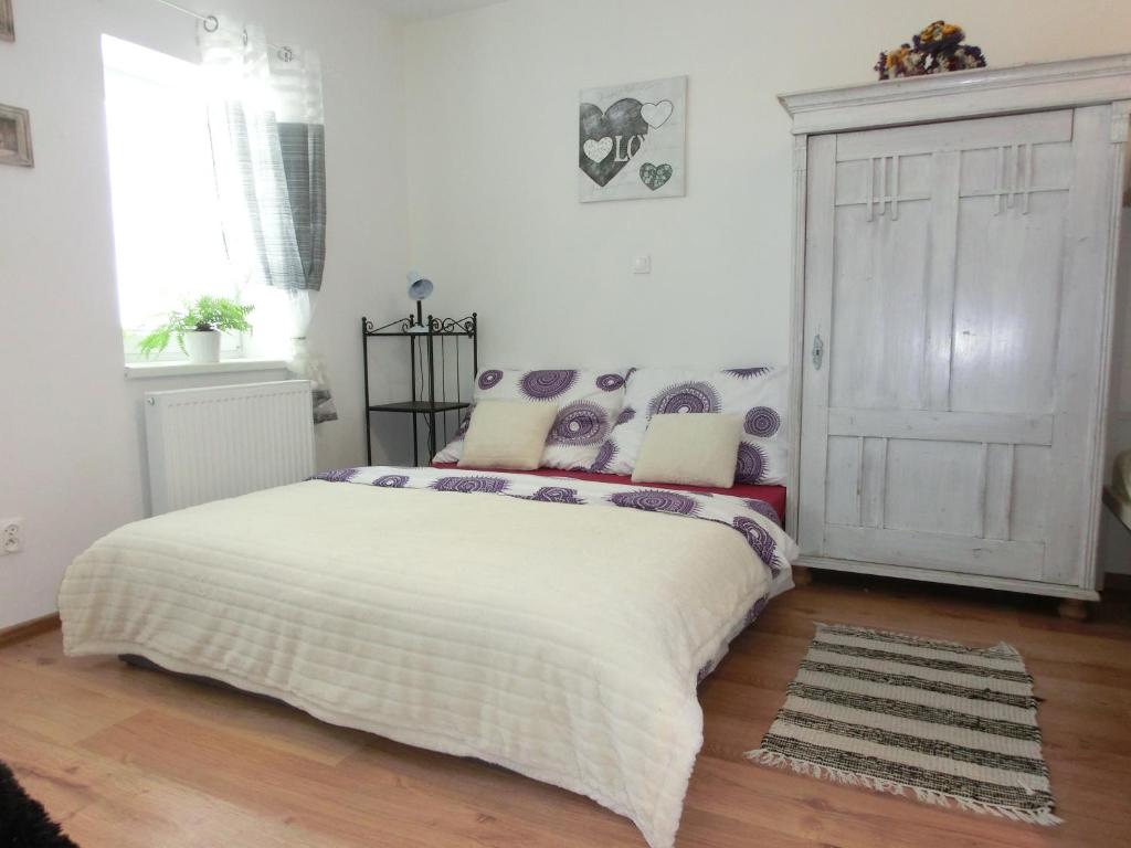 1 dormitorio con 1 cama con colcha blanca en Pension Skalka, en Liberec