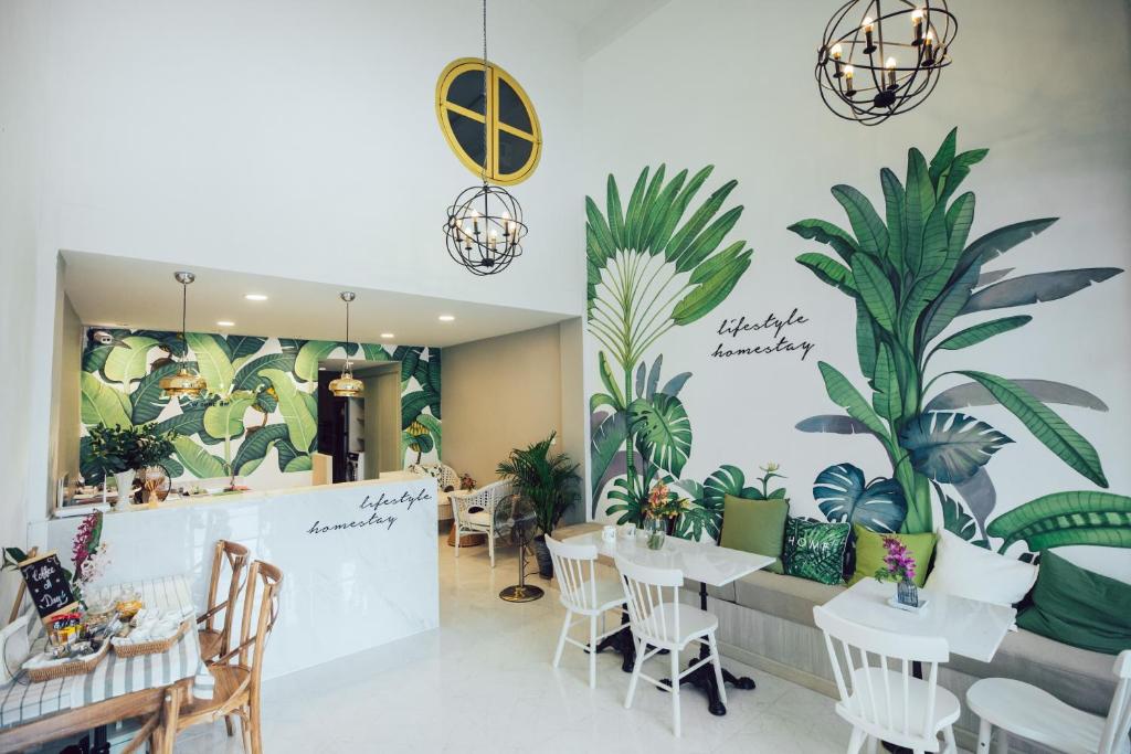 un restaurante con mesas y plantas en la pared en J's Cafe and Poshtel en Chiang Mai