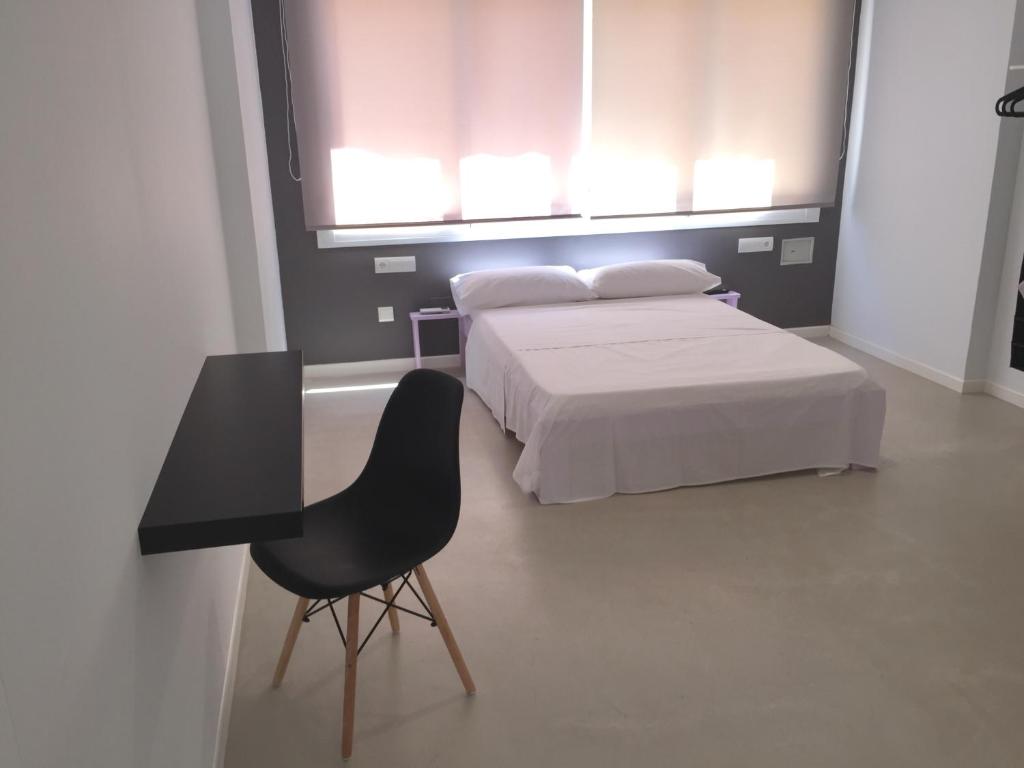 a bedroom with a bed and a table and a chair at SolRoom (plz. La Nogalera) in Torremolinos