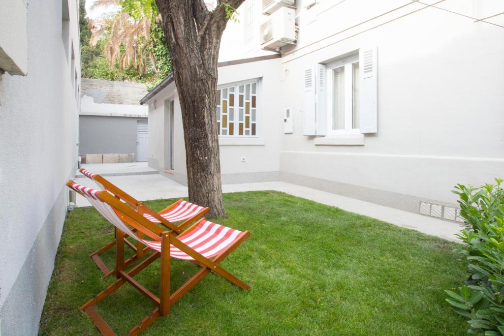 a patio with a chair and a tree at Apartment Splendido in Split
