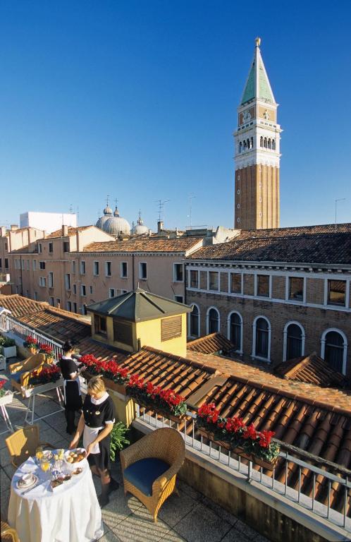 a couple of people standing on a roof with a table at Albergo San Marco in Venice