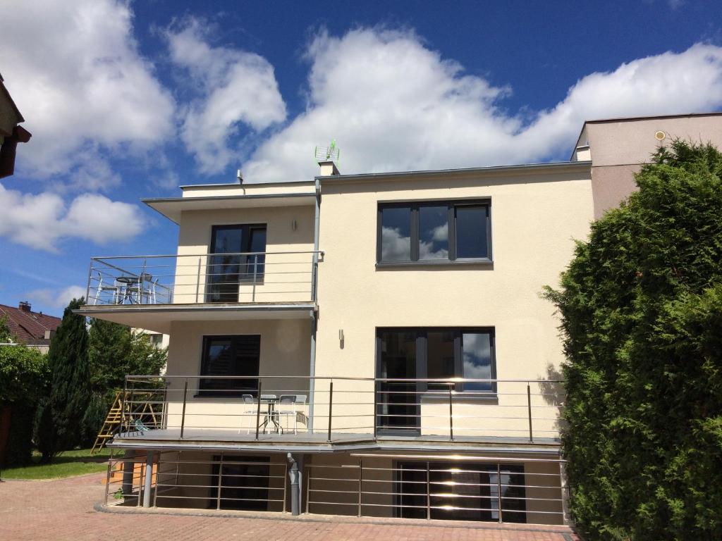 a large white house with a large balcony at Apartamenty Rodzinne Puck Katarzyna Pietruszkiewicz in Puck