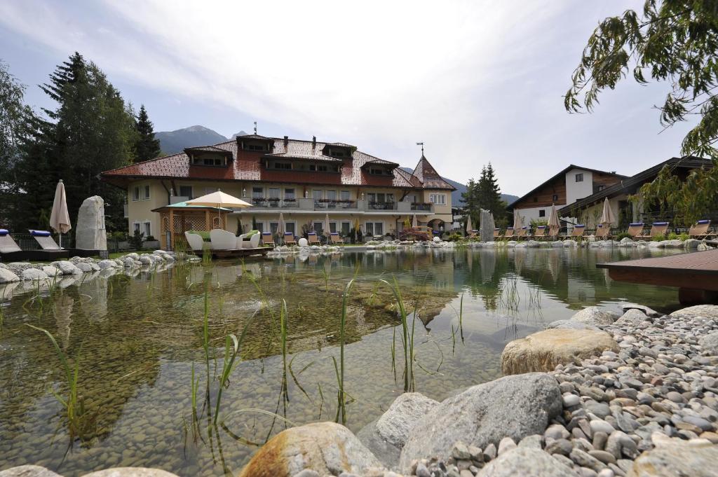 a resort with a pond in front of a building at Wellnesshotel Schönruh - Adults only in Seefeld in Tirol