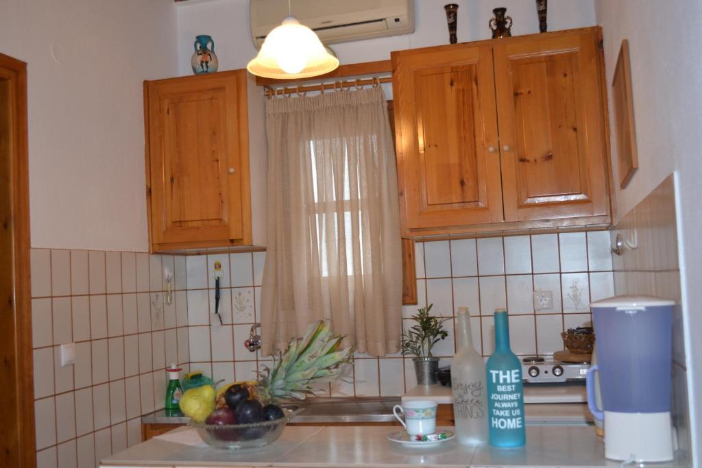 a kitchen with wooden cabinets and a counter top at Studios Flora Manos in Platis Gialos
