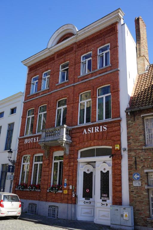 un bâtiment en briques rouges avec un hôtel situé sur son côté dans l'établissement Hotel Asiris, à Bruges