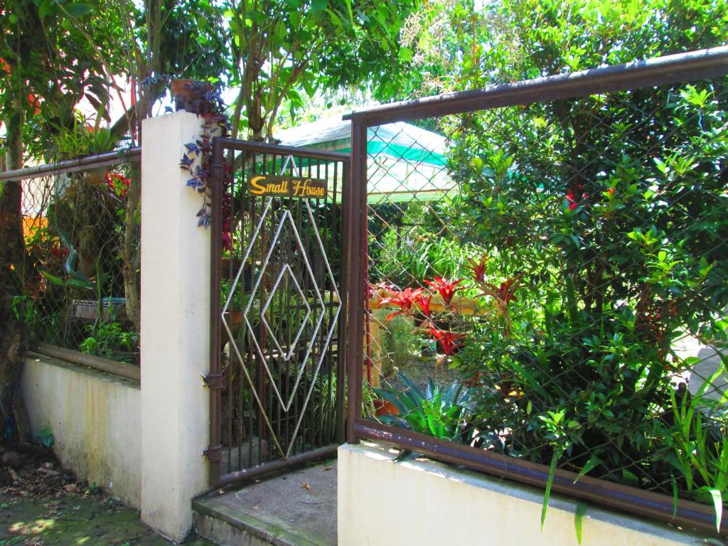 a gate to a garden with flowers and plants at Small House - Baguio in Baguio