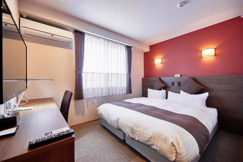 Postel nebo postele na pokoji v ubytování Hotel KAN-RAKU Saitama Honjo-Waseda Hinoki No Yakata