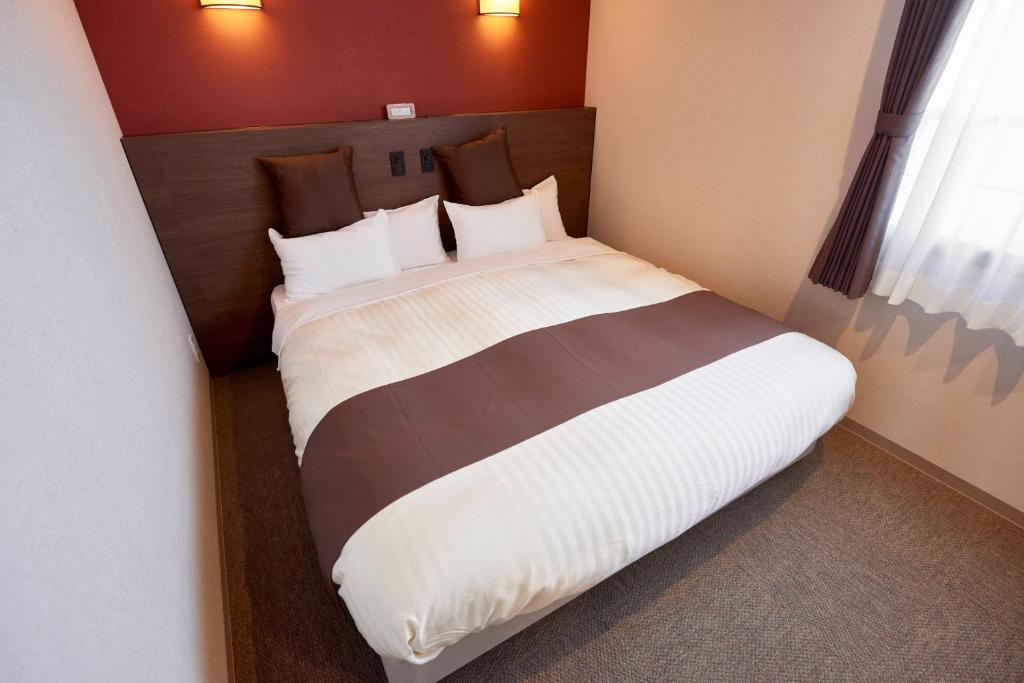 Postel nebo postele na pokoji v ubytování Hotel KAN-RAKU Saitama Honjo-Waseda Hinoki No Yakata