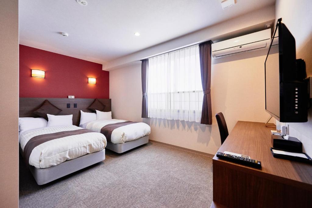 Postel nebo postele na pokoji v ubytování Hotel KAN-RAKU Saitama Honjo-Waseda Hinoki No Yakata