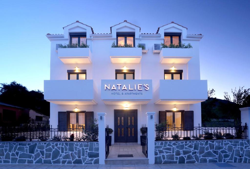 a white building with a sign that reads natalie at Natalie's Hotel in Skala