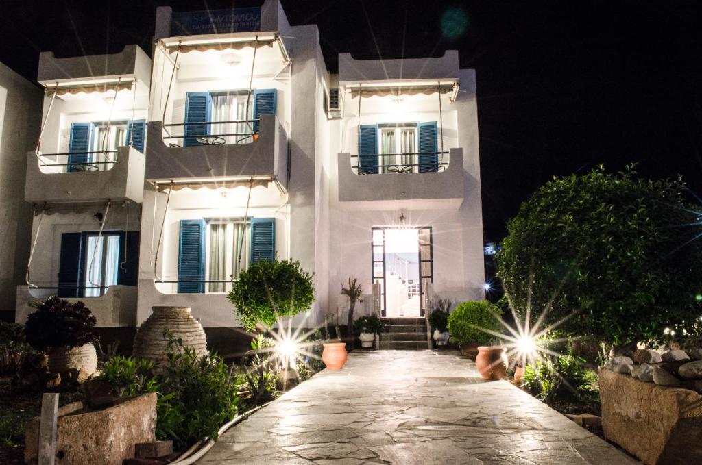 a white house at night with a walkway at Studios Antoniou in Skala