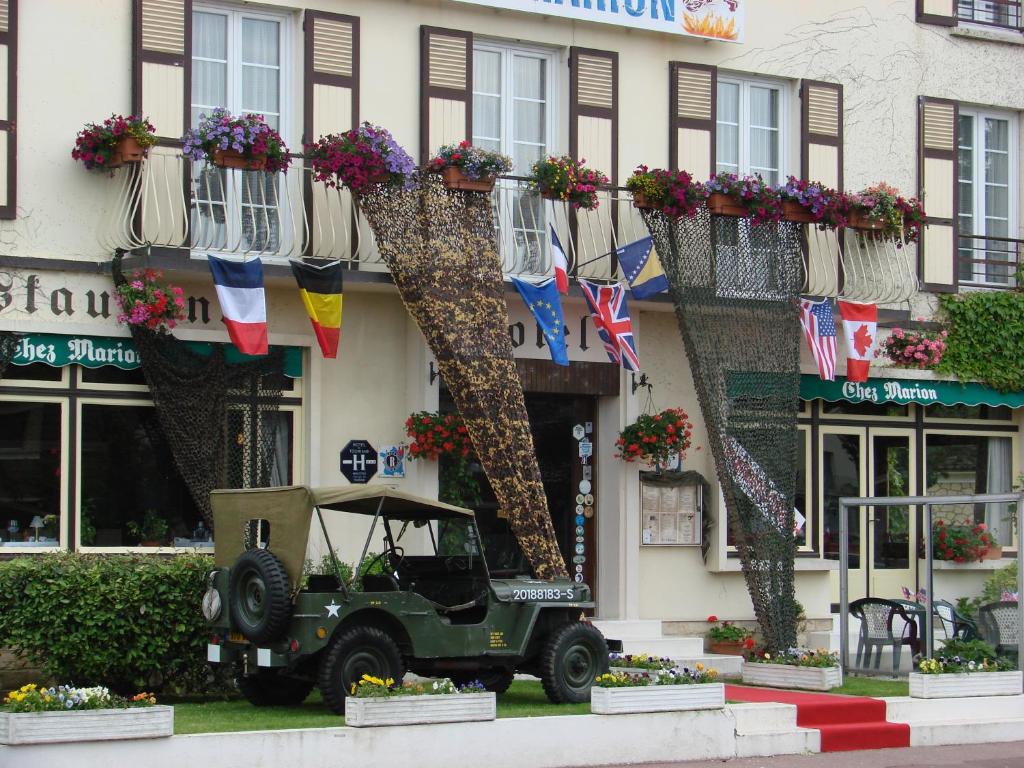 un jeep verde estacionado frente a un edificio en Chez-Marion, en Merville-Franceville-Plage