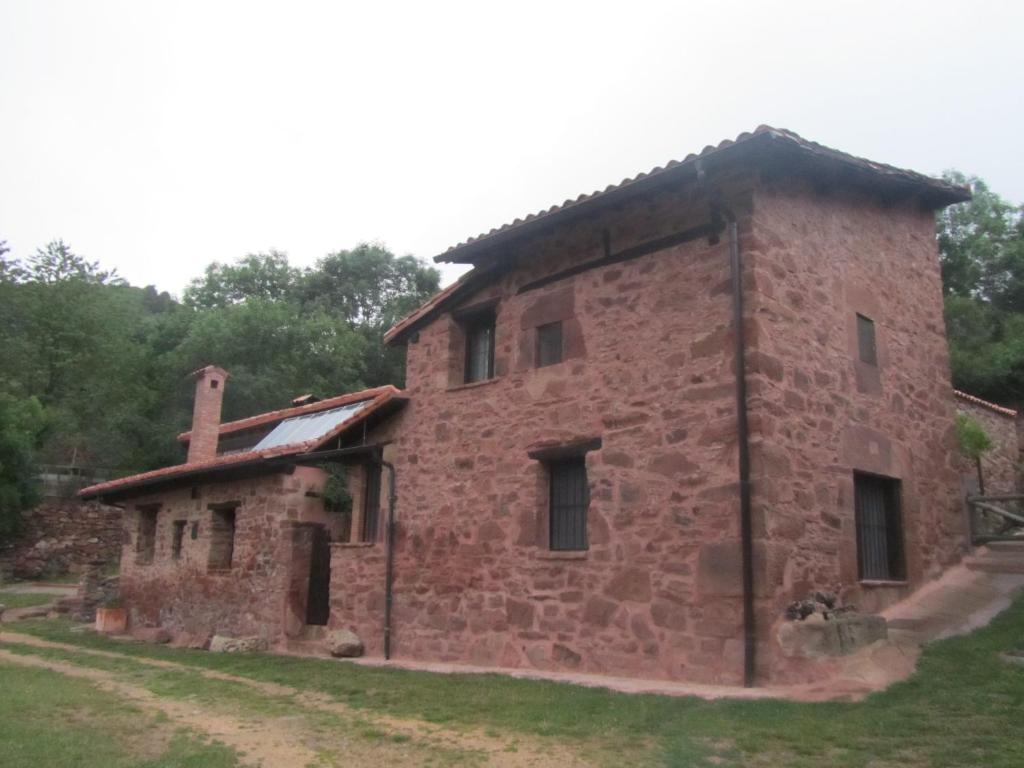 um velho edifício de tijolos num campo em Casa de Montaña La Solana de Turza em Turza