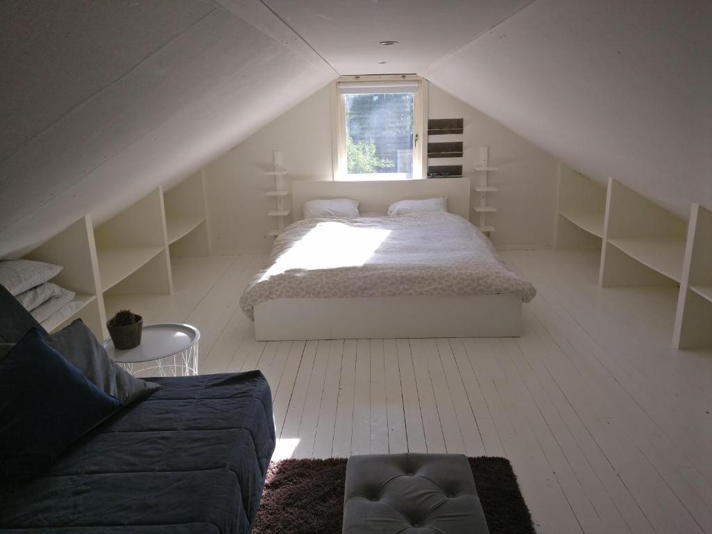 a white bedroom with a bed and a window at Lägenhet Färjestaden in Färjestaden