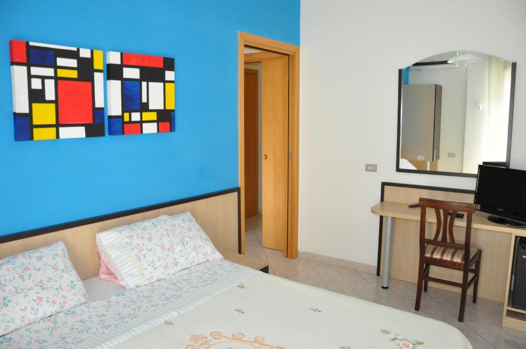 a bedroom with a bed and a desk and a painting at Bed & Breakfast Oasi in Pescara