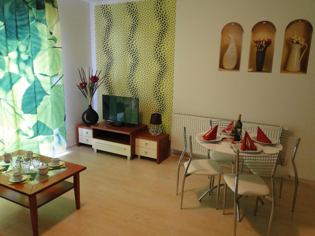 a living room with two tables and a tv at Apartments Liptov City in Liptovský Mikuláš