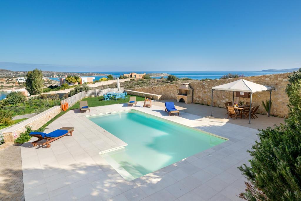 una piscina con patio, tavolo e sedie di Crete View a Marathi