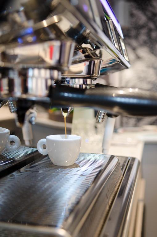 a coffee cup is being poured into a coffee machine at Hôtel le XIX in Béziers
