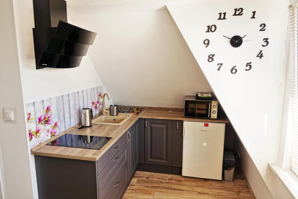 a kitchen with a sink and a clock on the wall at Przy Mickiewicza in Dziwnów