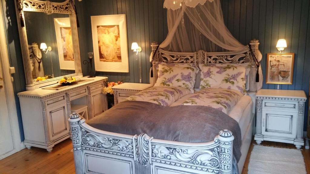 a bedroom with a large white bed with a canopy at Solheim Overnatting in Bø