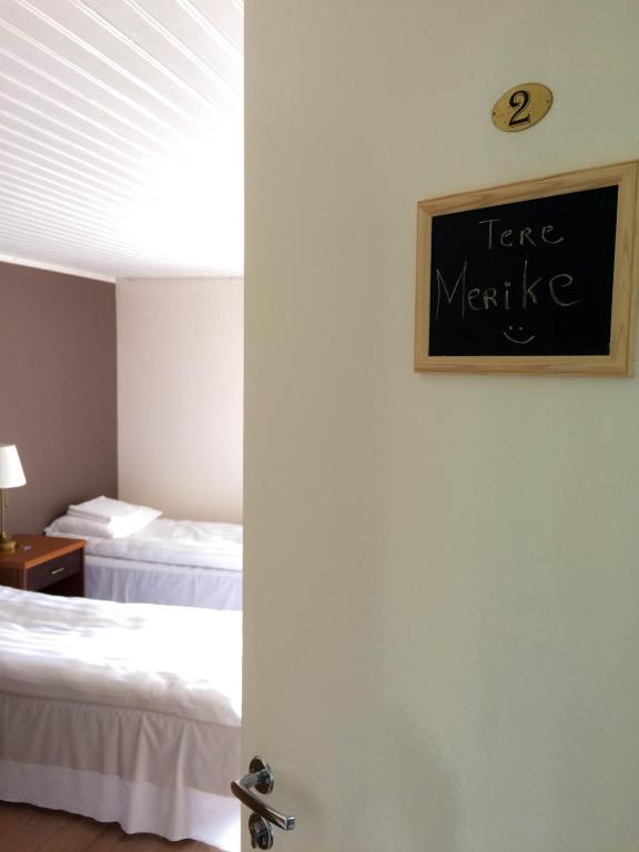 a room with two beds and a chalkboard on the wall at UusAllika Puhkemaja in Haapsalu