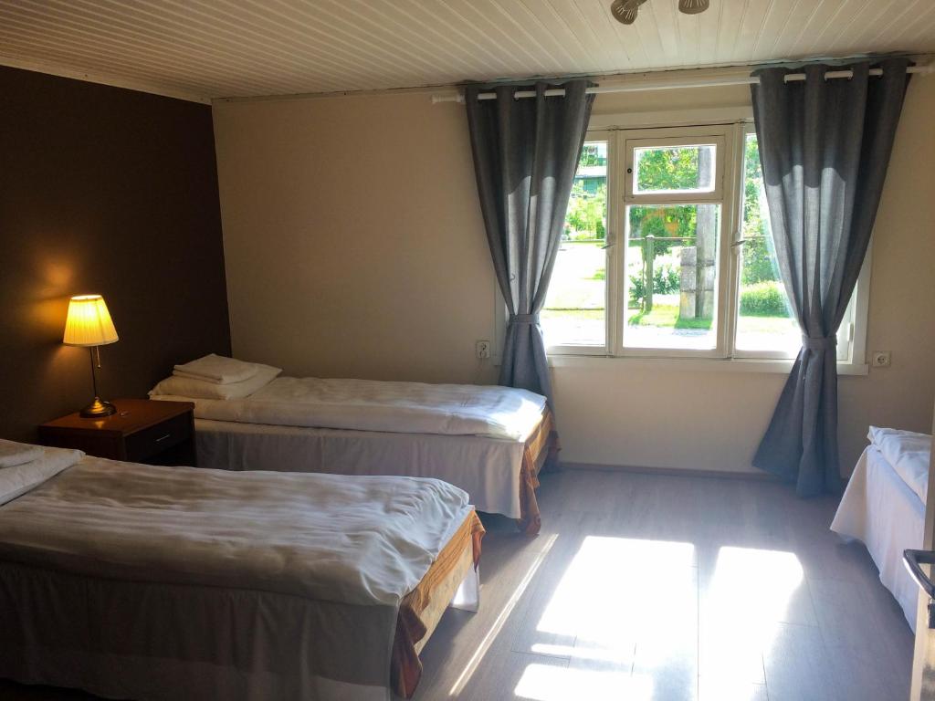a hotel room with two beds and a window at UusAllika Puhkemaja in Haapsalu