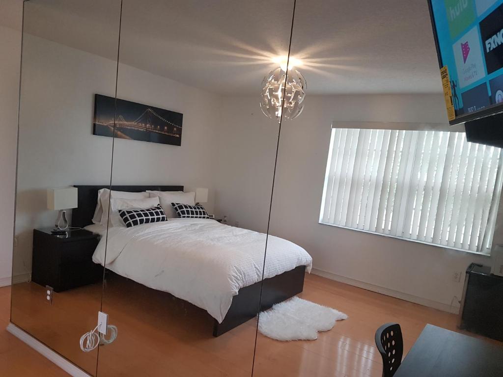 - une chambre avec un lit et une paroi en verre dans l'établissement Sawgrass, à Sunrise