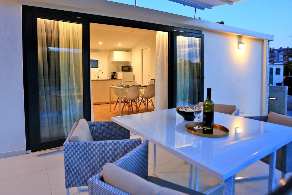 - une table blanche avec une bouteille de vin sur le balcon dans l'établissement First apartment Zadar, à Zadar