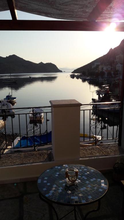 a table on a balcony with a view of a body of water at Kamares Studios in Symi