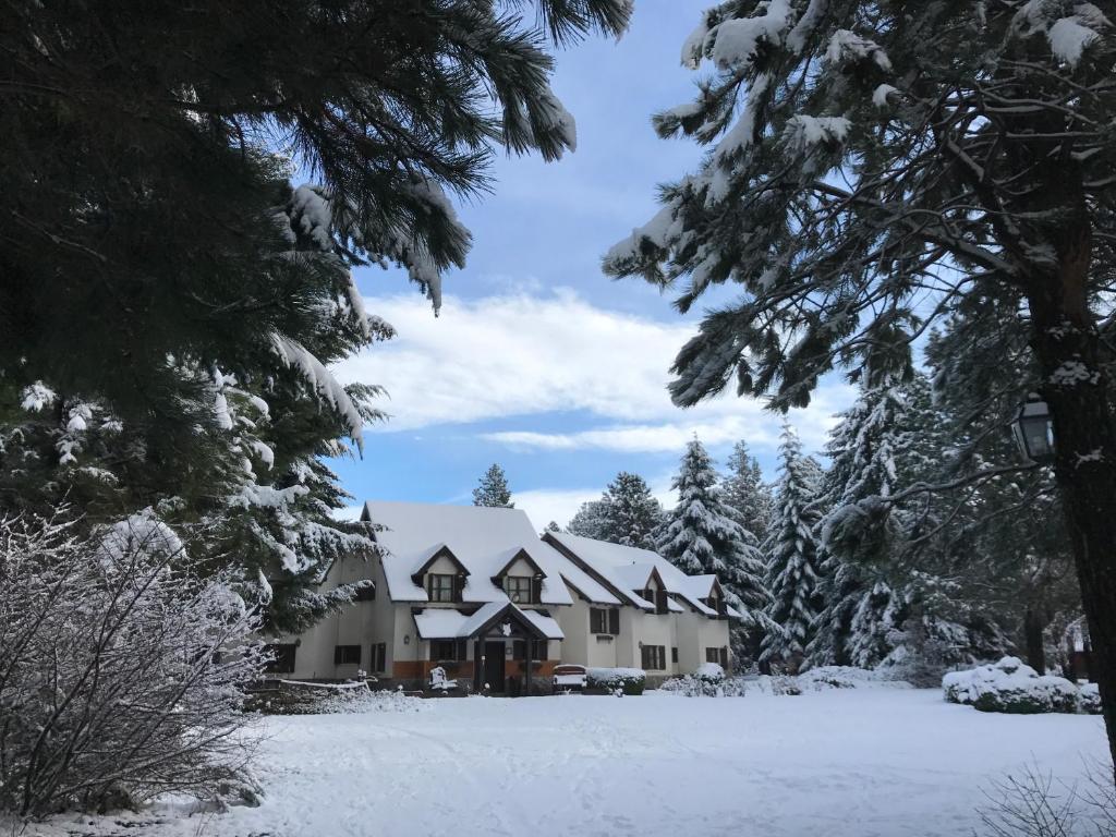 una casa en la nieve con árboles nevados en Posada del Angel en San Carlos de Bariloche