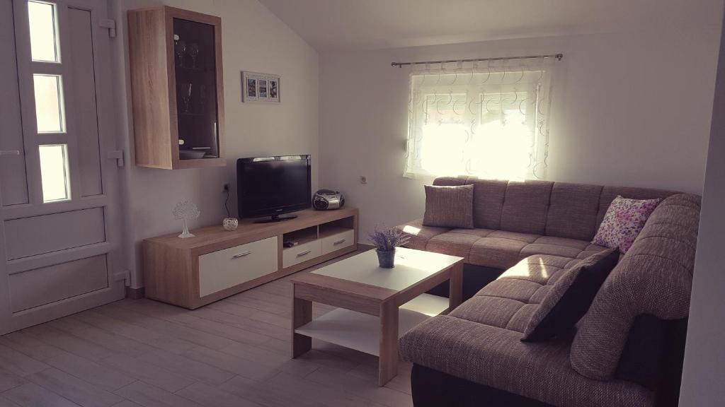 a living room with a couch and a tv at Apartment VIP in Pirovac