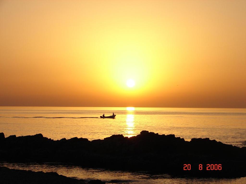 a person in a boat in the ocean at sunset at Hostal - Restaurante Playa Azul in Villaricos