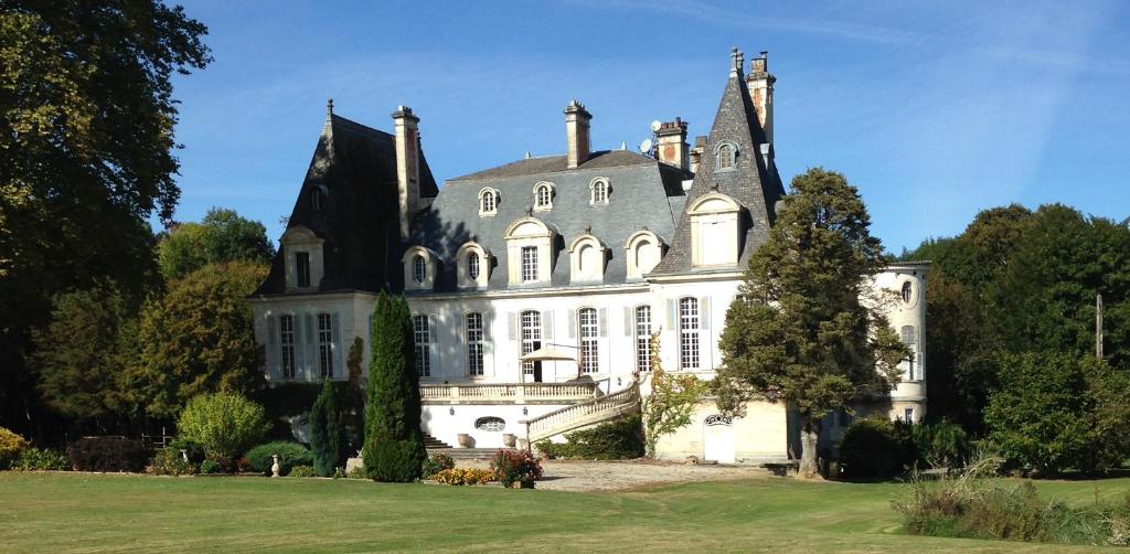 ein großes weißes Haus mit grauem Dach in der Unterkunft Chateau du Val Larbont in La Bastide-de-Sérou