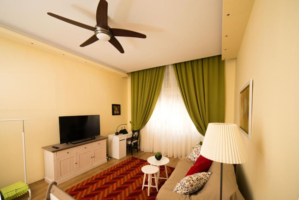 sala de estar con sofá y ventilador de techo en Rox Central Apartments 2, en Timisoara