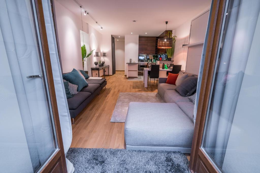 a living room with two couches and a kitchen at Le Balcon de la Vieille Ville Annecy in Annecy