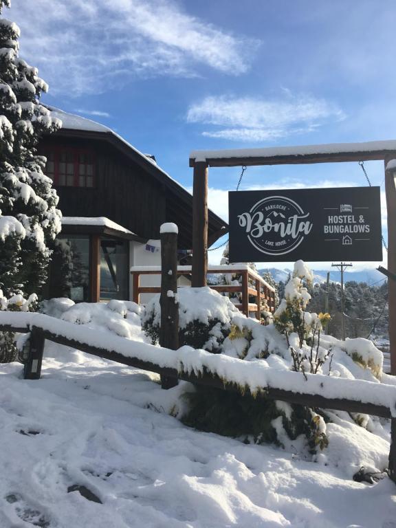 znak w śniegu przed budynkiem w obiekcie Bonita Lake House - Hostel & Bungalows w mieście Bariloche