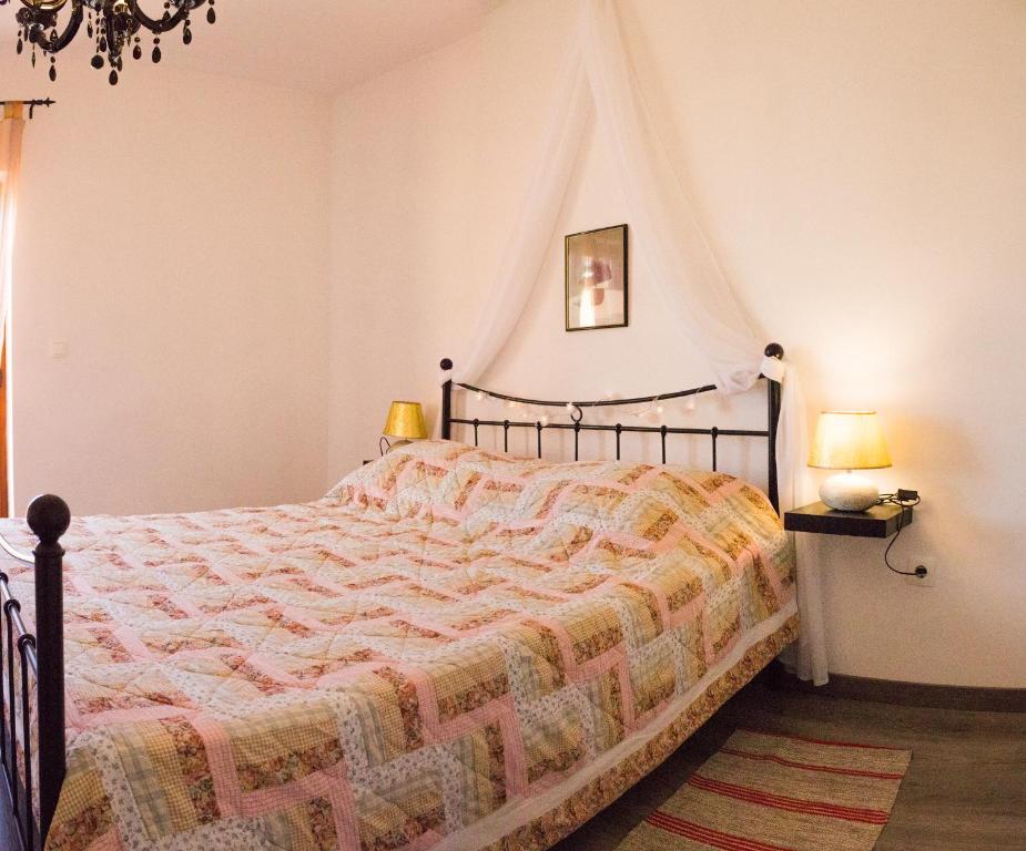 een slaapkamer met een bed met een dekbed en 2 lampen bij Apartment Dore in Krk