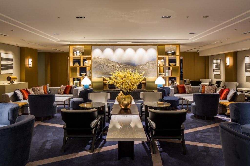 a hotel lobby with a waiting room with tables and chairs at Keio Plaza Hotel Tokyo Premier Grand in Tokyo